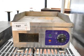 Stainless steel electric flat top griddle, 110V, 1 phase, includes power and heat controls, auction tag visible.