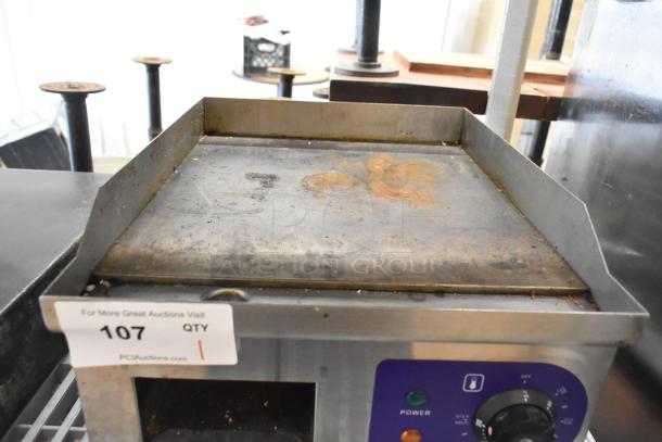 Stainless steel commercial electric griddle, countertop model, 110 volts, with power controls, worn cooking surface.