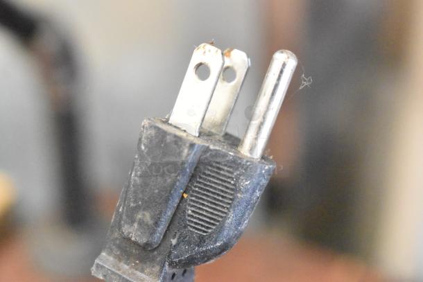 Close-up of a three-prong plug for a 110V stainless steel commercial countertop electric griddle.