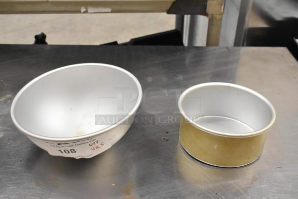 Metal baking bowl and round pan on table; auction tag reads "108, QTY 5." Surfaces show light wear.