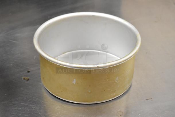 Round metal baking pan, silver interior, slightly worn exterior, part of a collection of 5 metal baking items.
