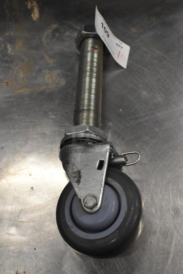 Commercial caster with metal swivel mount, gray wheel, and pin lock. Includes lot tag with "108" and "VIP" markings.