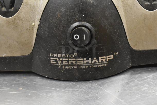 Presto EverSharp electric knife sharpener, black with metallic accents, visible logo, in used condition on metal surface.