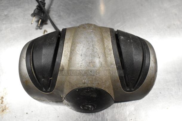 Presto Eyersharp knife sharpener, used condition, metal and black plastic, visible power cord, on stainless surface.