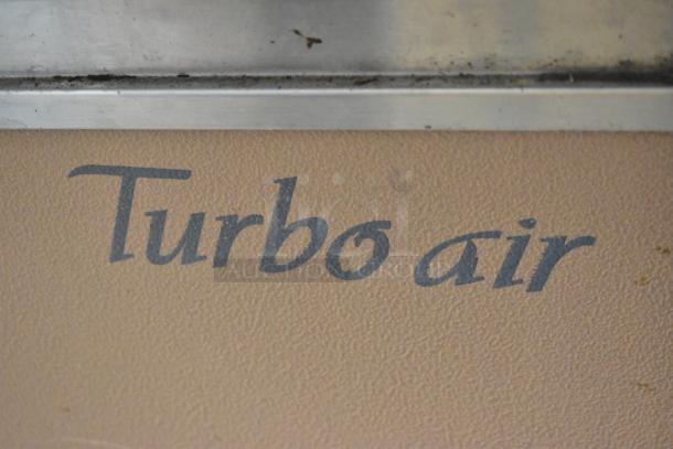 Turbo Air TB-5R logo on metal surface of commercial refrigerated bakery case. Model for floor style curved glass display.
