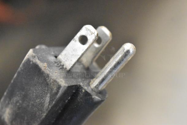 Close-up image of a dusty, worn metal electrical plug for NP-229 waffle maker, showing three prongs.