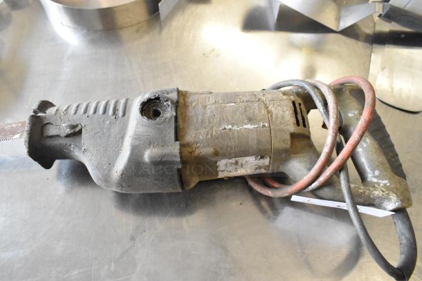 Electric jigsaw, 115 volts, 1 phase, used condition, worn exterior with visible wear marks and cords.