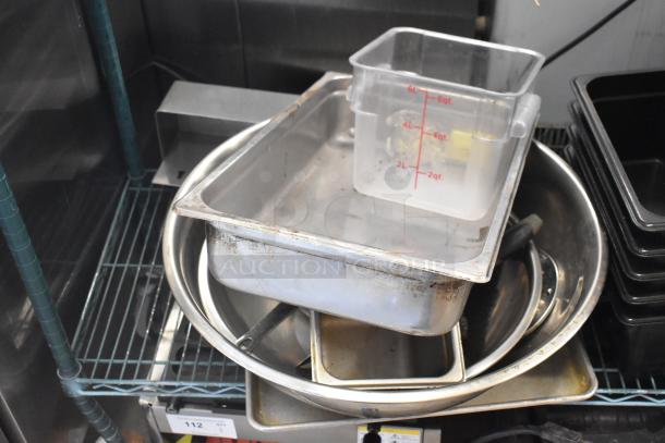 Metro lot with poly bins, stainless steel drop-in bins, and mixer attachments. Visible wear on items. No shelving included.