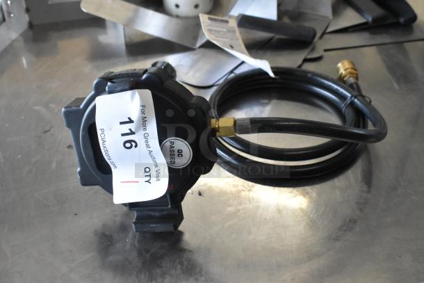 Gas hose with attached regulator, QC passed label, auction tag 116. Black tubing with brass fittings, appears in good condition.