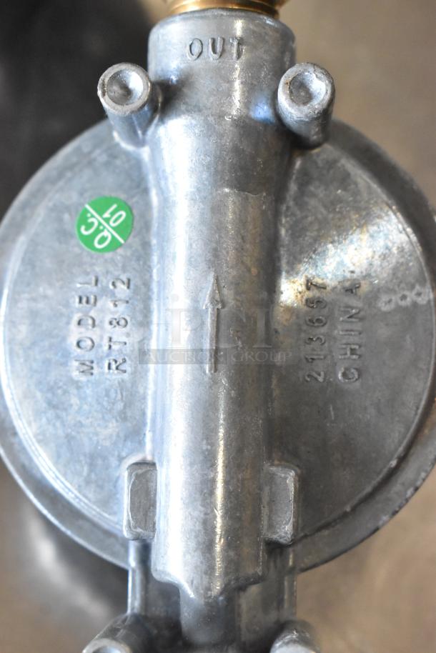 Metal gas hose connector, model RT81-2, with "OUT" marking and arrow. Green label, made in China, serial 213697.