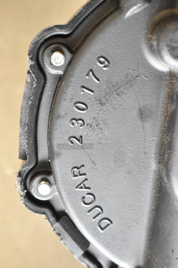 Close-up of a black metal component with "Ducar 230179" stamped on it, possibly part of a gas hose assembly.