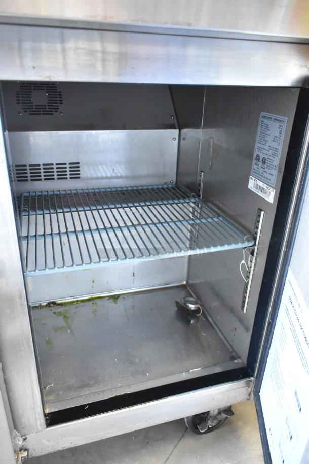 Dukers DUC72R stainless steel commercial 3-door undercounter cooler on casters; labels highlight model and specs; interior view.