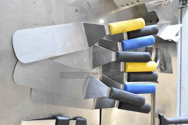 Lot of various kitchen utensils including metal spatulas with colored handles, paddle, and cake collars. Good condition.