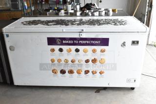 Kelvinator KCCF210WH metal chest freezer with hinge lid. Visible wear on top, attached cookie poster, 115V, 1 Phase.