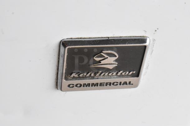 Kelvinator KCCF210WH chest freezer, metal body, hinge lid, commercial logo visible. 115V, 1 Phase, model KCCF210WH.