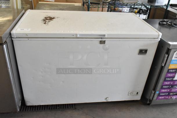 Kelvinator KCCF140WH metal chest freezer with hinge lid, 115 volts, 1 phase, visible wear on top, dented exterior.