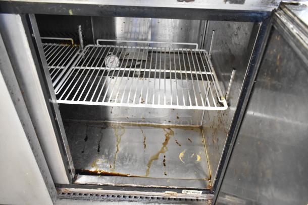 2017 Bison BUR-72 stainless steel commercial 3-door undercounter cooler, interior view, showing signs of wear.