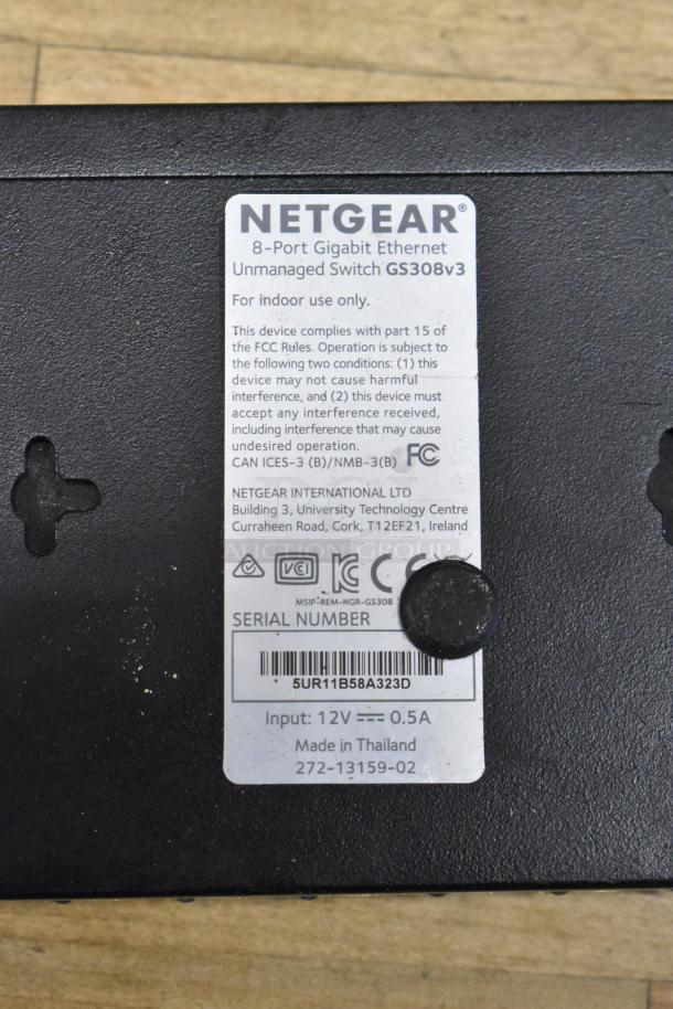Netgear 8-Port Gigabit Ethernet Switch GS308v3, label indicating model, compliance, serial number, 12V input, made in Thailand.
