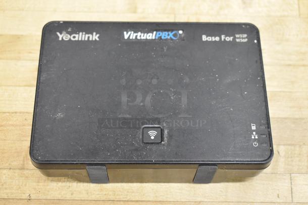 Yealink VirtualPBX base unit, black, with visible Wi-Fi symbol. Model markings for W52P, W56P on top surface.