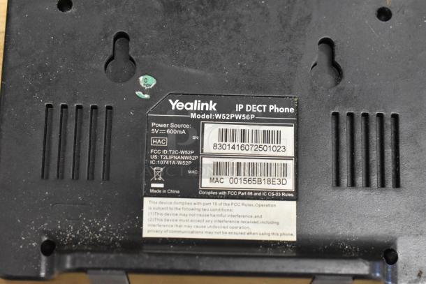 Yealink IP DECT Phone Model W52PW56P with visible labels showing power source, serial number, and MAC address.