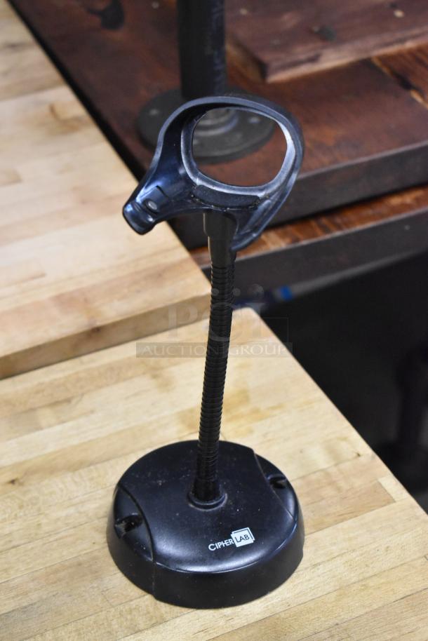 POS system component, CipherLab scanner stand, black, used condition, on a wooden surface.