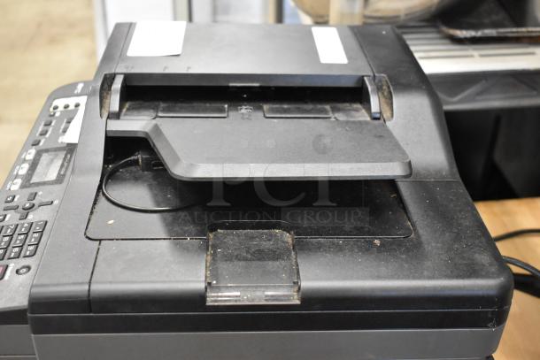 Brother MFC-L2710DW multifunction printer, copier, scanner in used condition, visible markings, minor surface dust.