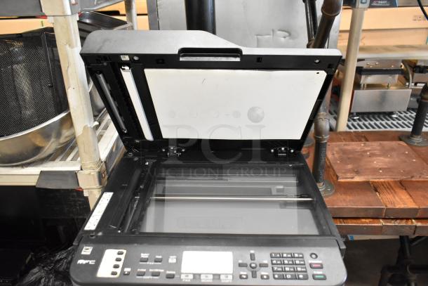 Brother MFC-L2710DW printer, scanner, copier with open lid showing glass bed and control panel. In used condition.