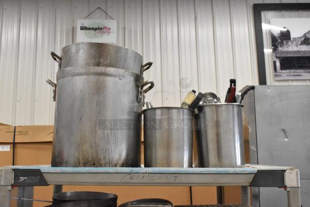 Lot of 3 tiers including stock pots, stainless steel bins, and bowls on a metal shelf. Some items show wear.