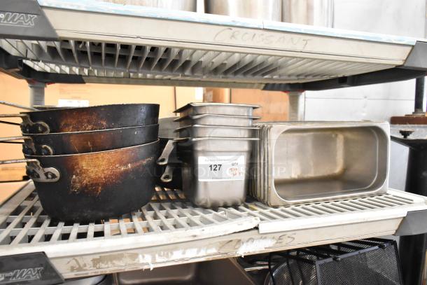 Lot of 3 tiers including stock pots, stainless steel bins, and bowls. Used condition. Auction tag with number 127 visible.