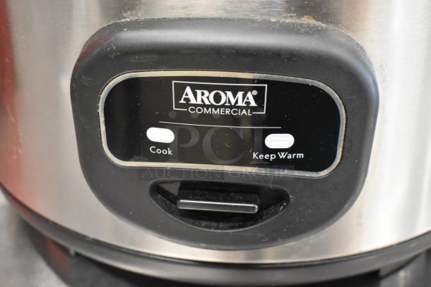 Aroma ARC-1130S stainless steel rice cooker with controls for cooking and keeping warm. Commercial branding visible.