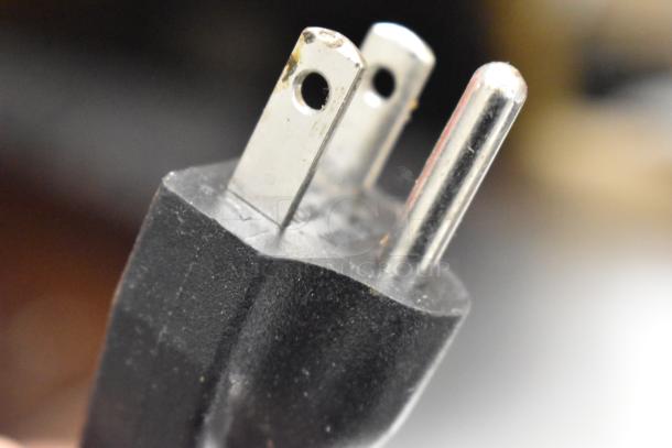 Close-up of a three-pronged electrical plug for the Aroma ARC-1130S rice cooker. Black plastic housing with metal prongs.