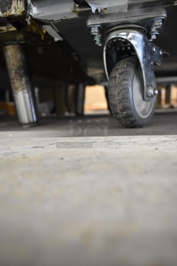 Close-up of a caster wheel on the 2024 Vevor KTR-48B1 stainless steel commercial undercounter cooler, showcasing mobility features.
