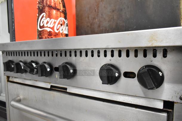 Mainstreet stainless steel commercial gas range with 6 burners, oven, over shelf, and backsplash. Slightly used condition.