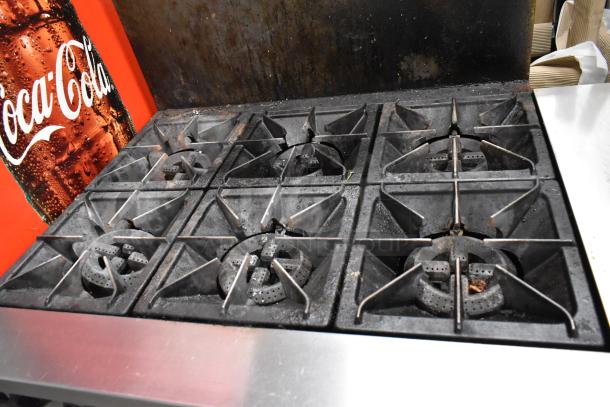 Mainstreet Stainless Steel Commercial 6 Burner Gas Range with oven, over shelf, and backsplash, in used condition.