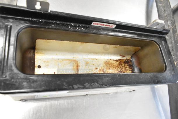 Server CW stainless steel utensil holder, countertop model, showing visible wear. "Caution-Hot" label on top.