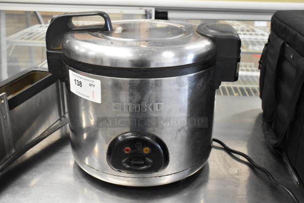 Amko AK-60ERC stainless steel countertop rice cooker, model AK-60ERC, 120 volts, shown with handles and auction tag.