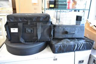 Four black bags with contents, various shapes and sizes, including a Teton bag with label, in good condition.