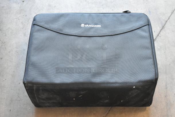Black Vanguard bag with visible logo, moderate wear. Contains unspecified items. Auction includes four such bags.