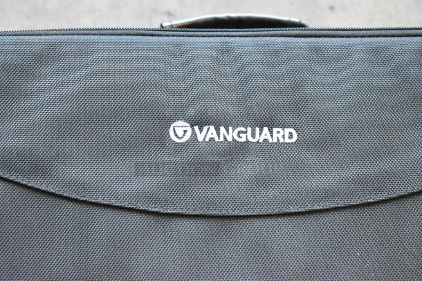 Vanguard black bag with logo visible, textured material, part of a set of 4 with contents, auction item.