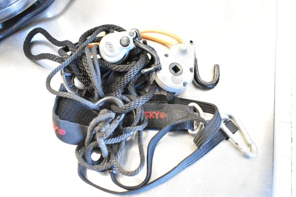 Climbing ropes with pulleys, black straps labeled "SKYLOTEC," and carabiners on a table. Appears in good condition.