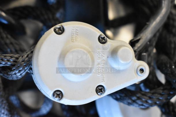 Close-up of mechanical component with text: "Break Strength 150LB 68KG," patent number visible. Part of auctioned bag contents.