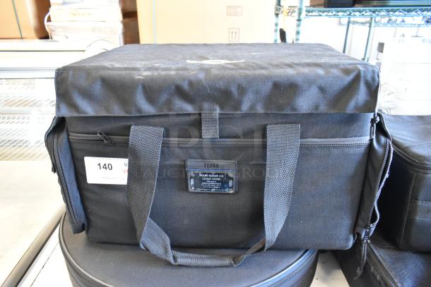 Four black Tenba bags with contents, wear on bags. Visible label with number 140. Durable fabric and sturdy handles.