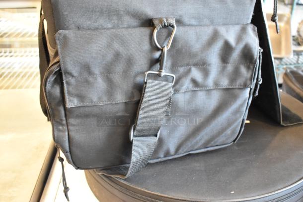 Black bag with front pocket, metal hook, and zipper; includes contents. Auction item: 4 bags, bid to multiply win.