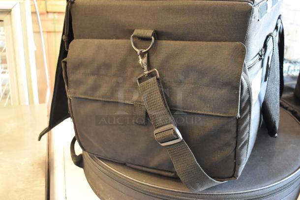 Four black bags with adjustable straps, durable fabric, and secure closures. Includes unidentified contents.