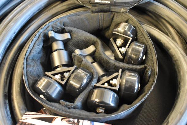 4 black bags with contents; includes wheels and components. Bag labeled "Made in India." Auction item: 4x your bid.