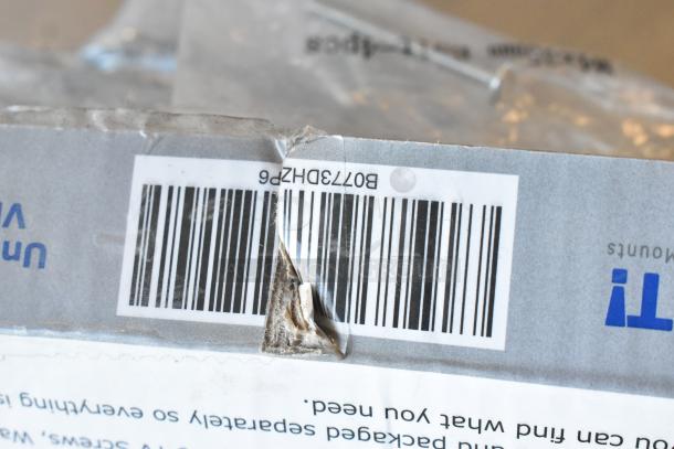 Lot of various items including 3 metal legs, universal gas hose, and universal TV mounting hardware pack. Box with barcode visible.