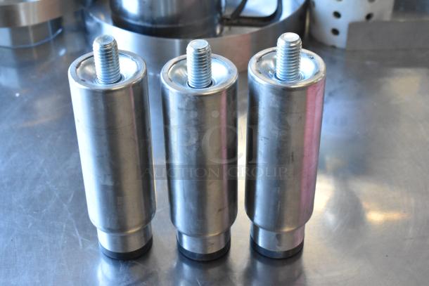 Metal legs set, featuring three silver cylindrical legs with threaded tops, on a reflective surface.