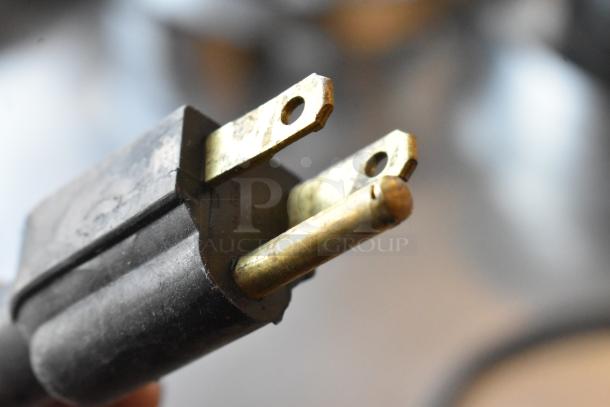 Close-up of FMP Zap Timer's power plug, showing its worn brass prongs. 115-volt, 1-phase electrical timer accessory.