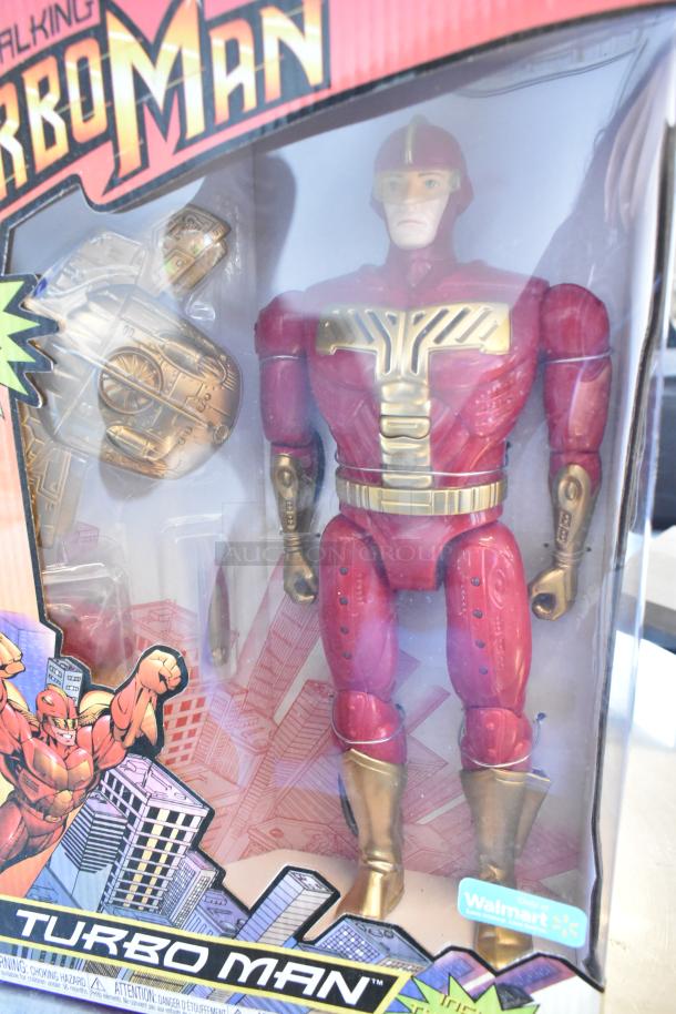 Boxed Turbo Man figurine, red and gold, in new condition. Features Walmart exclusive sticker and vibrant packaging design.