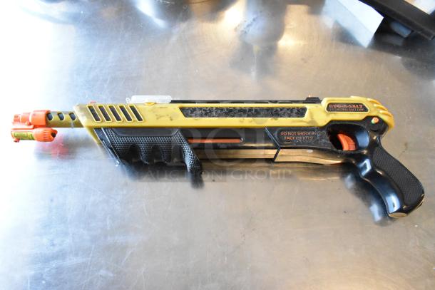Bug-A-Salt gun, used condition with visible wear. Yellow and black design. Label reads "Do not shoot in face or eyes."